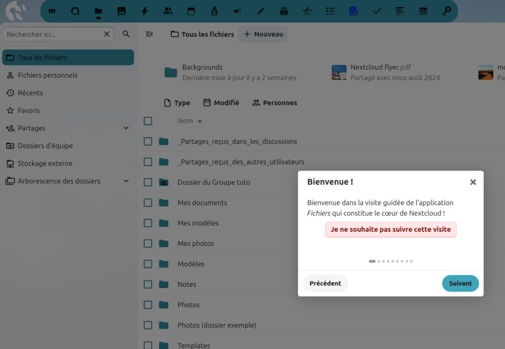 Interface de l'application Nextcloud affichant la liste des fichiers et dossiers. À gauche, un menu latéral propose des options comme 'Tous les fichiers', 'Fichiers personnels', 'Récents', 'Favoris', 'Partages', 'Dossiers d’équipe', et 'Stockage externe'. Au centre, une liste de dossiers partagés et personnels est visible, avec des informations sur leur type, leur date de modification et les personnes associées. Une fenêtre contextuelle de visite guidée est ouverte, avec le message : 'Bienvenue dans la visite guidée de l’application Fichiers qui constitue le cœur de Nextcloud !' et un bouton pour ignorer la visite.