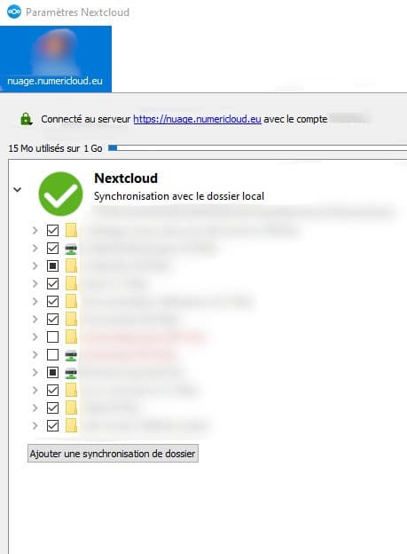 Capture d'écran de la fenêtre de synchronisation des fichiers. On y voit "Paramètres Nextcloud". Dessous la photo de profil de l'utilisateur son nom flouté et le nom du compte. Dessous l'adresse de connexion au serveur. Dessous le nombre de Mo disponible et à sa droite la quantité déjà utilisée. Dessous la liste de l'ensemble des fichiers présents sur l'instance, avec une case à cocher devant chacun pour l'inclure ou non dans la synchronisation.