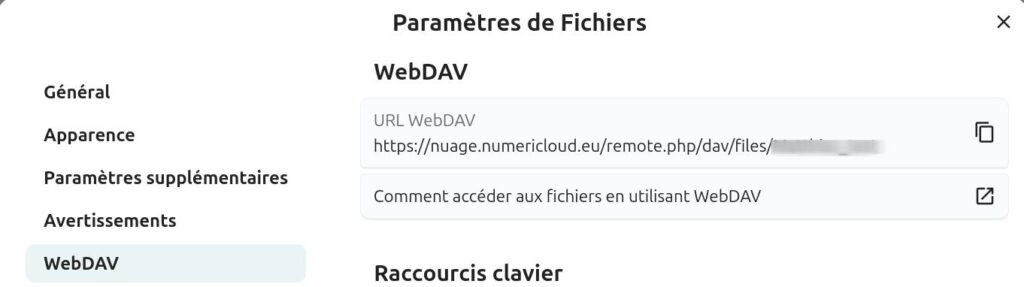 Interface des paramètres de fichiers dans Nextcloud, onglet 'WebDAV' sélectionné. À gauche, un menu latéral propose les sections : 'Général', 'Apparence', 'Paramètres supplémentaires', 'Avertissements', et 'WebDAV' (sélectionné).
À droite, la section WebDAV affiche une URL personnelle pour accéder aux fichiers via WebDAV : 'https://nuage.numericloud.eu/remote.php/dav/files/[utilisateur]'.
Un lien 'Comment accéder aux fichiers en utilisant WebDAV' est disponible pour obtenir des instructions supplémentaires.
En bas, la section 'Raccourcis clavier' est visible mais non détaillée.