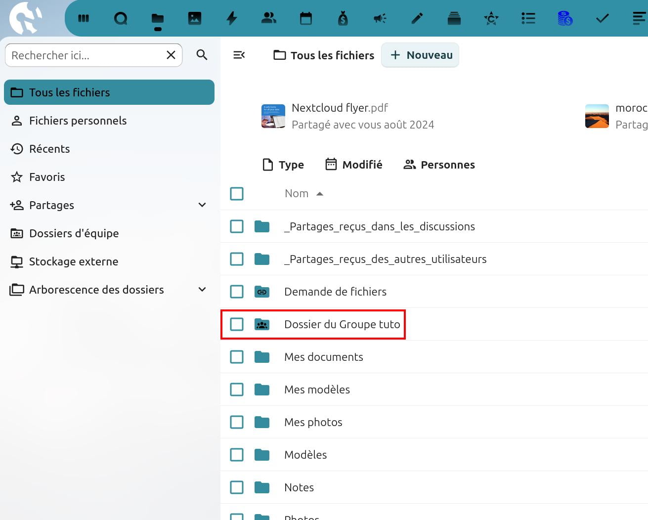 Interface de Nextcloud affichant la liste des fichiers et dossiers. À gauche, un menu latéral propose les sections : 'Tous les fichiers' (sélectionné), 'Fichiers personnels', 'Récents', 'Favoris', 'Partages', 'Dossiers d’équipe', 'Stockage externe', et 'Arborescence des dossiers'.
À droite, une barre d'outils permet de rechercher, de filtrer par type, date de modification ou personnes, et d’ajouter un nouveau fichier.
La liste des dossiers et fichiers inclut :
Un fichier 'Nextcloud flyer.pdf' partagé en août 2024,
Des dossiers comme '_Partages reçus dans les discussions', '_Partages reçus des autres utilisateurs', 'Demande de fichiers',
Le dossier 'Dossier du Groupe tutos' (encadré en rouge),
D'autres dossiers personnels comme 'Mes documents', 'Mes modèles', 'Mes photos', 'Modèles', 'Notes', et 'Photos'