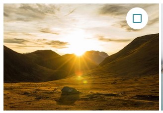 Capture d'écran d'une image qui représente un paysage avec des montagnes derrières lesquelles se couche le soleil. Dans le coin droit en haut une case à cochée entourée d'un cercle blanc.