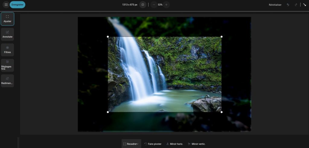 Capture d'écran d'une photo ouverte dans le panneau des modifications. A gauche 4 boutons, "Ajuster" (dans lequel on est), "Annotate", "Filtres fins", "Réglages" et "Redimen...". Dans la partie basse au centre 4 boutons, "Recadrer" (ce qui est en train d'être fait), "Faire pivoter", "Miroir horiz." et "Miroir vertic.". Dans le reste de l'écran une image sur lequel a débuté un recadrage, de fait on voit clairement la partie centrale sur lequel le recadrage est fait et de façon plus sombre et flou tout le reste qui est hors du recadrage.