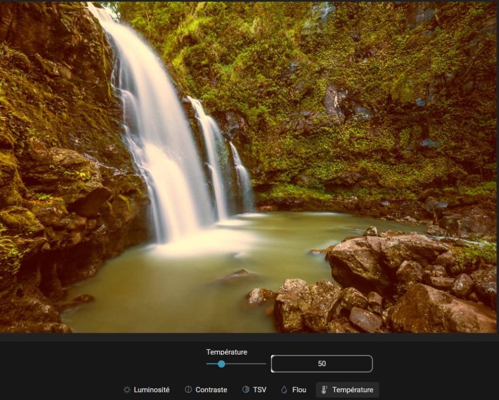 Capture d'écran d'une image (une cascade) ouverte dans la partie "Réglages fins", "Température" des modifications. dans la partie basse le paramètre pour la température est un petit rond à tirer vers la droite ou la gauche pour modifier le contraste. Sur la droite de cette réglette, un champ avec un chiffre indiquant le taux de température. En-dessous il y a 5 items, "Luminosité", "Contraste", "TSV", "Flou" et "Température".